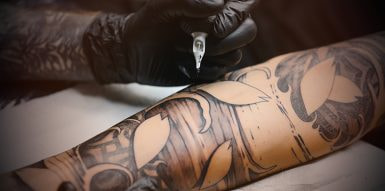 Tattoo majstor radi tetovažu na ruci drugoj osobi